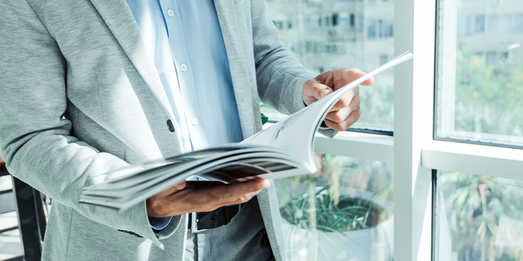 Man reading a magazine in office